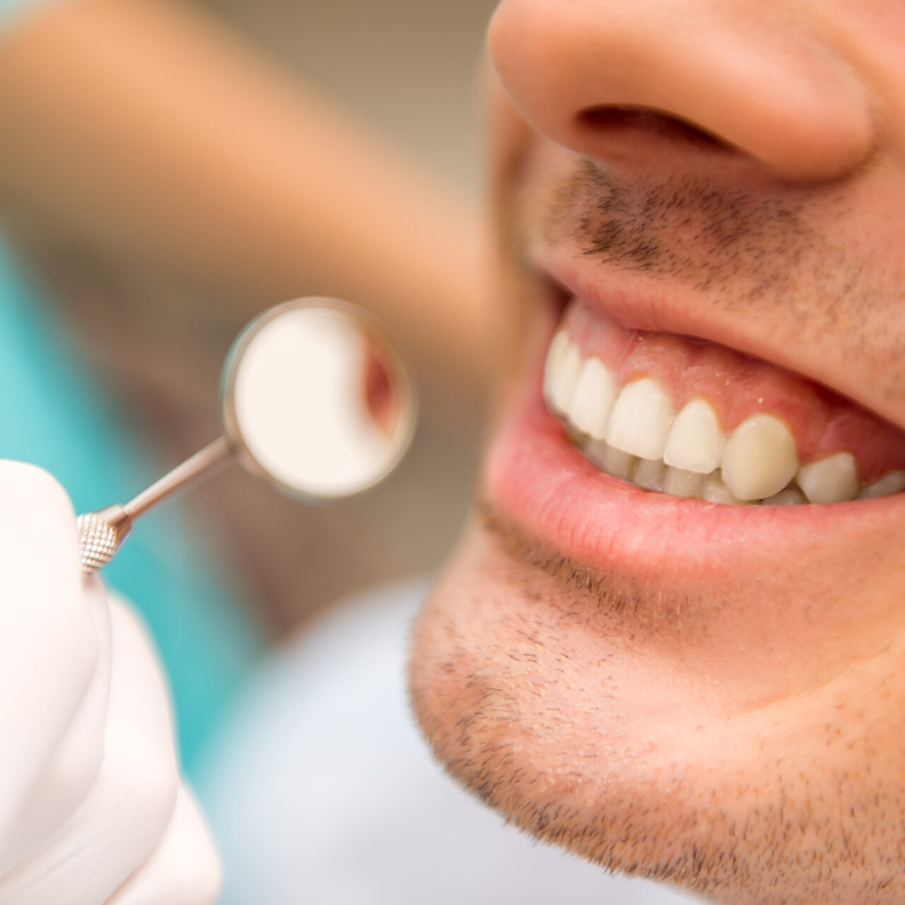 Close-up. Beautiful white teeth man on a review of the dantist